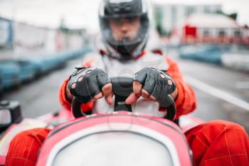 Karting race, go cart driver in helmet on carting speed track. Go-kart racer