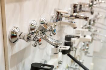 New kitchen water faucets on the shelf closeup, plumbing shop, nobody