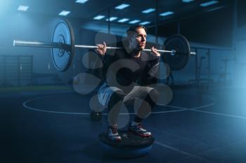 Strength athlete on training, workout with barbell in gym. Active sport exercises in fitness club