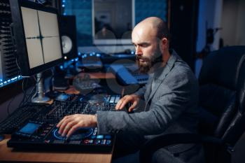 Sound engineer working at the remote control panel in the recording studio.  Musician at the mixer, professional audio mixing