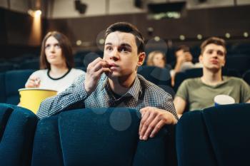 Scared man watching movie in cinema. Showtime, entertainment