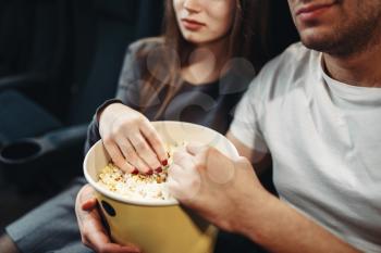 Love couple with popcorn watching movie in cinema. Showtime, entertainment industry