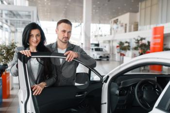 Couple buying new car in showroom. Male and female customers choosing vehicle in dealership, automobile sale