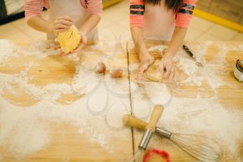 Two little girls chefs crumple the dough, cookies preparation on the kitchen, funny bakers. Kids cooking pastry, children cooks preparing cake