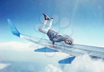 Dance performer, dancing exercise on the plane wing. Modern dance style. Male dancer in the air