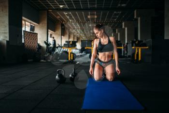 Female athlete trains press in sport gym, top view. Young woman in fitness club, fit training