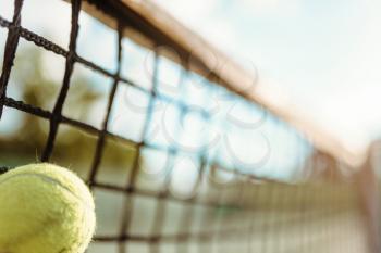 Ball in net closeup, big tennis concept, outdoor court. Professional game equipment