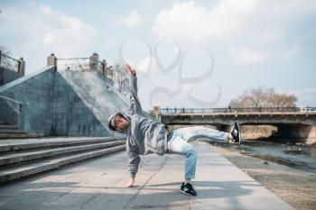 Dance performer, hip hop dancing  on the street. Modern dance style. Male dancer, cityscape on background