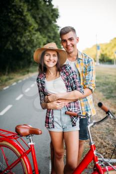 Love couple walk on vintage bikes, romantic journey of young man and woman. Boyfriend and girlfriend together outdoor, retro bicycle