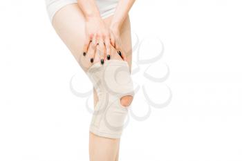 Joint ache, female person with leg bandage, knee pain, white background. Woman in lingerie, medical advertising or concept