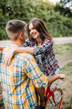 Young man and woman kissing, romantic date, retro bikes. Happy love couple with vintage bicycle. Boyfriend and girlfriend together outdoor