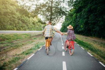 Love couple riding on vintage bikes. Romantic journey of young man and woman.