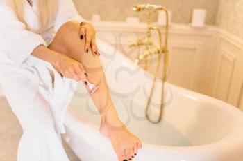 Female person shaves legs in bathroom, skincare. Bodycare and hygiene, healthcare