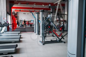 Gym interior, nobody, exersice machines and sport equipment in fitness club