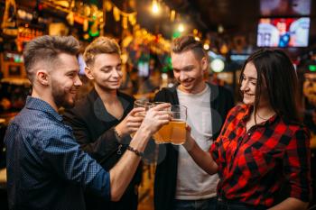 Happy football fans raised their glasses with beer at the bar counter in a sport pub, victory celebration