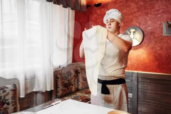 Male chef in apron and hat making dough on the kitchen. Homemade apple strudel cooking, sweet dessert preparation