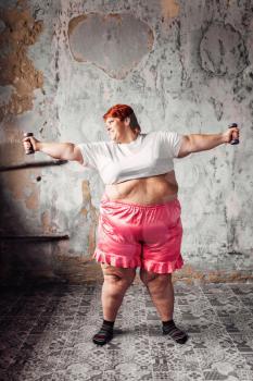 Fat woman on physical workout with dumbbells, fight against obesity, overweight problem. Fastfood eating