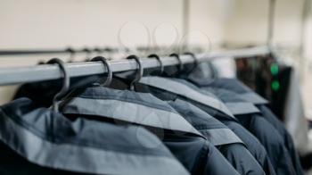Clothes on a hangers, sewing factory or dress fabric. Jackets on a racks