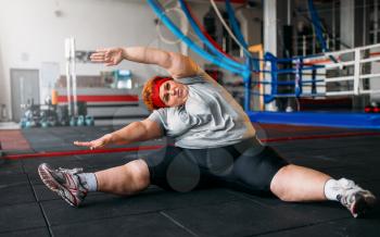 Fat woman exercises on the floor, workout in gym. Calories burning, obese female person, training in sport club