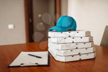 Pizza delivery concept, delivering service, nobody. Pizzeria business, carton boxes, cap and empty blank on the table