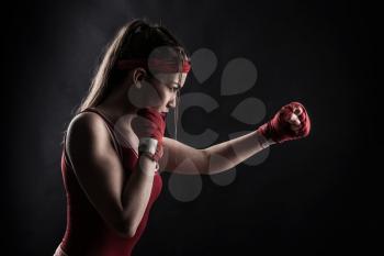 Female boxer in red boxing bandages and sportswear training. Fighting sport concept