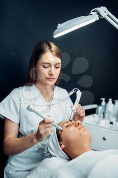 Face rejuvenation procedure to woman, beauty medicine, cosmetology clinic. Facial skincare in spa salon, health care