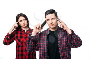 Always online, addicted people concept. Man talking on two phones at the same time, woman don't like it, white background