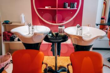 Modern wash basins in hairdressing salon, nobody. Professional hairdresser equipment, haircut tools in beauty studio
