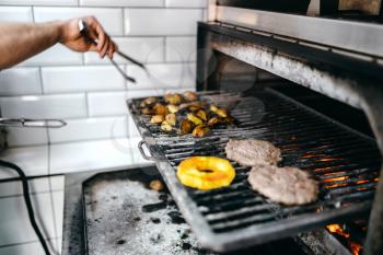 Cook hands prepares smoky meat on grill oven, burger cooking. Hamburger preparation process, fast food, bbq