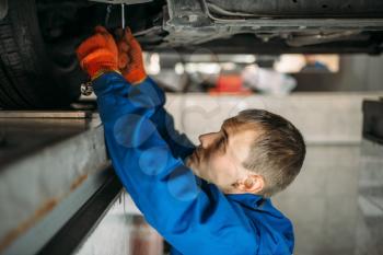 Mechanic adjusts the wheel angles on stand in auto-service. Computer diagnostic of car suspension, collapse of convergence