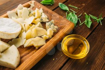 Cheese, oil and herb on wooden table closeup, top view, nobody. Garnish for meat, food preparation, cooking