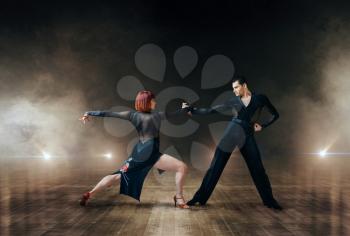 Elegant dancers in costumes, latin ballrom dance on stage. Female and male partners on professional pair dancing on theatre scene