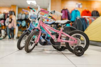 Rows of children's bicycles in sports shop, nobody. Summer active leisure for kids, showcase with bikes for young riders, cycle sale