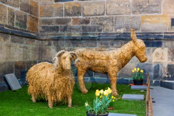 Stuffed animals from hay on lawn, old European town. Summer tourism and travels, famous europe landmark, popular places and streets