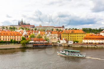 Prague cityscape with pleasure boat on river, Czech Republic. European town with ancient architecture buildings, famous place for travel and tourism