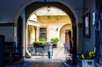 Sidewalk cafe in the courtyard, ancient European city. Summer tourism and travels, famous europe landmark, popular places