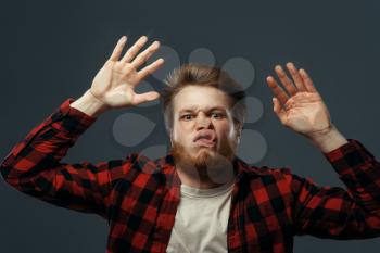 Young man's funny face crushed on transparent glass. Male person with pressed grimace standing at the showcase, humor