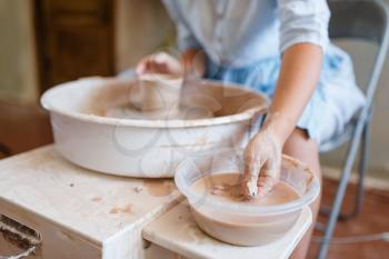 Female master making a pot on pottery wheel. Woman molding a bowl. Handmade ceramic art, tableware from clay