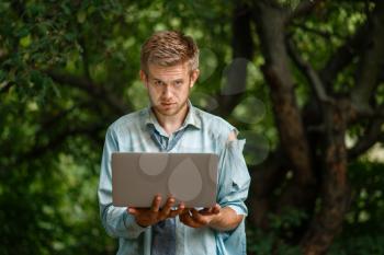 Alone businessman with laptop on desert island. Business risk, collapse or bankruptcy concept
