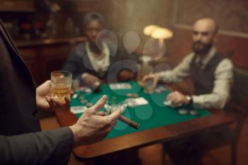 Three poker players sitting at the table in casino. Games of chance addiction, gambling house,