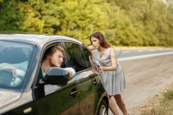 Young woman pushing broken car with man on road, breakdown. Crashed automobile or emergency accident with vehicle, trouble with engine on highway