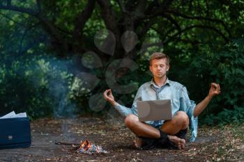 Alone businessman with laptop at the fireplace on desert island. Business risk, collapse or bankruptcy concept