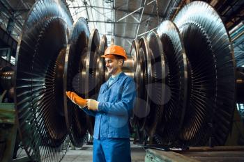 Male worker checks turbine impeller vanes on factory. Industrial production, metalwork engineering, power machines manufacturing