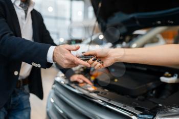 Man and salesgirl choosing auto in car dealership. Customer and seller in vehicle showroom, male person buying transport, automobile dealer business