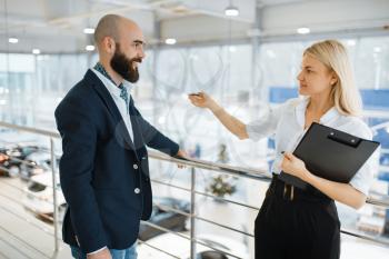 Female seller invites man to presentation in car dealership. Customer and saleswoman in vehicle showroom, male person buying transport, automobile dealer business