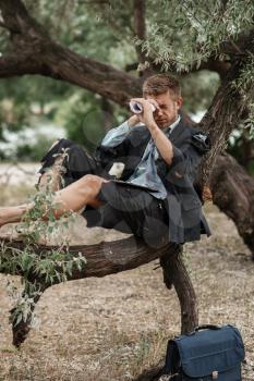 Alone businessman in torn suit resting on the tree on lost island. Business risk, collapse or bankruptcy concept