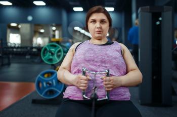 Overweight woman doing exercise in sport club, fitness training with instructor. Female person struggles with excess weight, aerobic workout against obesity, gym