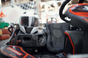 Helmet in go kart car closeup view, karting auto sport indoor. Speed racing go-kart track. Fast vehicle competition, hot pursuit