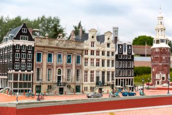 People on the street, ancient building, cyclists, miniature scene outdoor, europe. Mini figures with high detaling of objects, realistically diorama