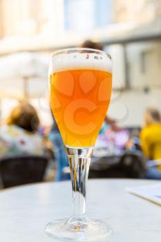 Beer in glass on the table in street cafe in old European tourist town. Summer tourism and travels, famous europe landmark, popular places for travelling